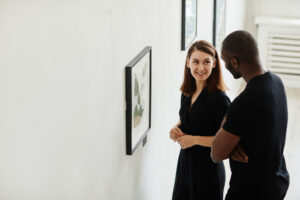 Zwei Menschen unterhalten sich vor einem Gemälde