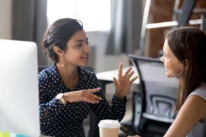 Zwei junge Frauen unterhalten sich im Büro über eine Idee